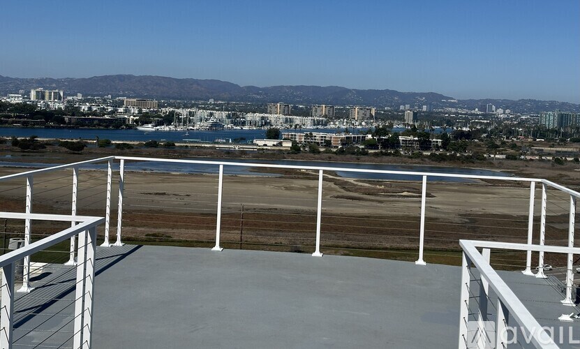 A white railing overlooks a cityscape.