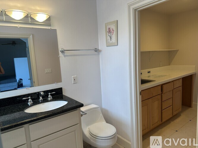 A bathroom with a sink, toilet, and mirror.