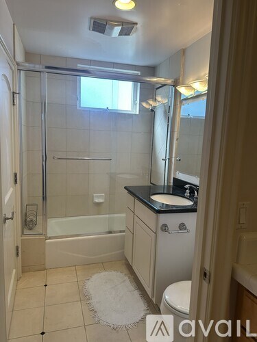 A bathroom with a toilet, sink, and shower.