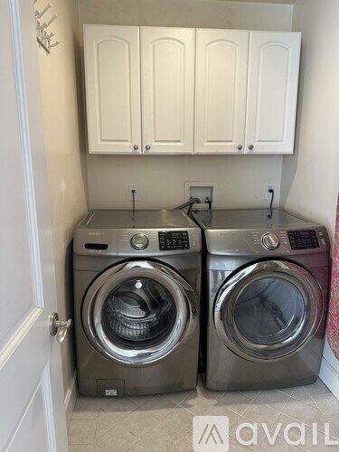Two front load washing machines in a small laundry room.