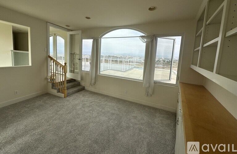 A spacious living room with a staircase leading to the upper level.
