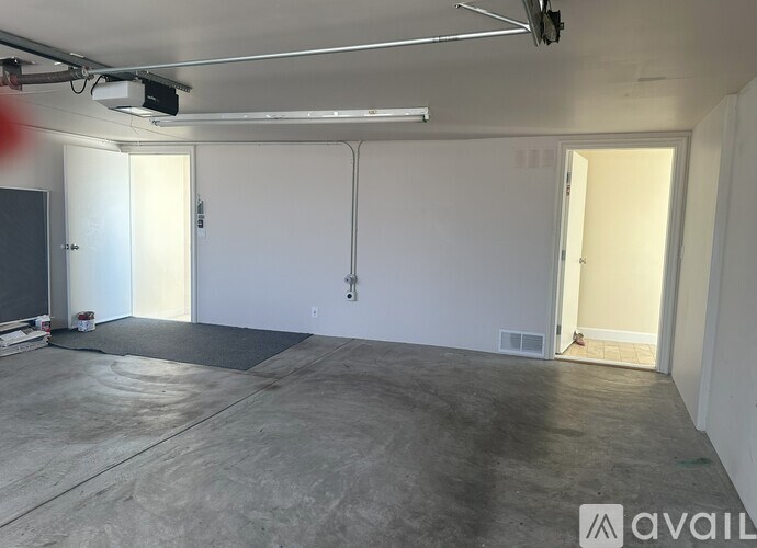 A large empty room with a concrete floor and white walls.