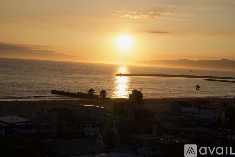 A sunset over a beach with a small town in the foreground.