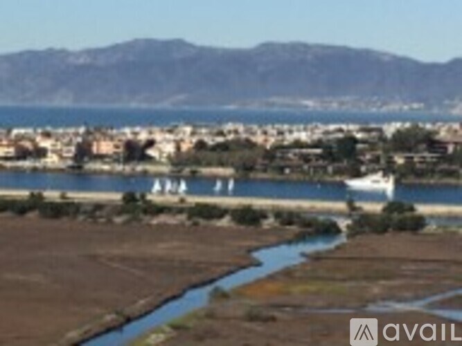 A river flows through a valley with a town and mountains in the background.