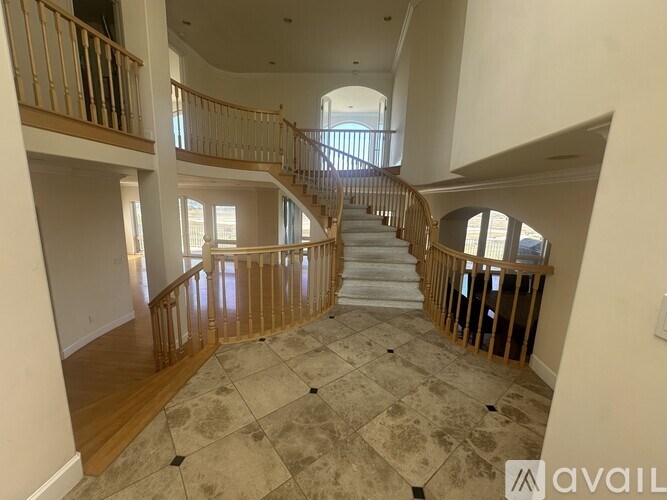 A large, open foyer with a staircase and a tiled floor.