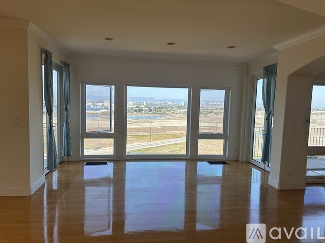 A spacious room with large windows overlooking a view.