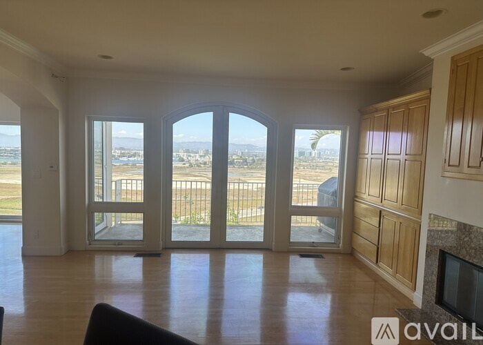 A living room with a view of the city through large windows.