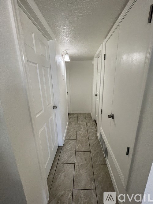 A hallway with white doors and tiled floors.