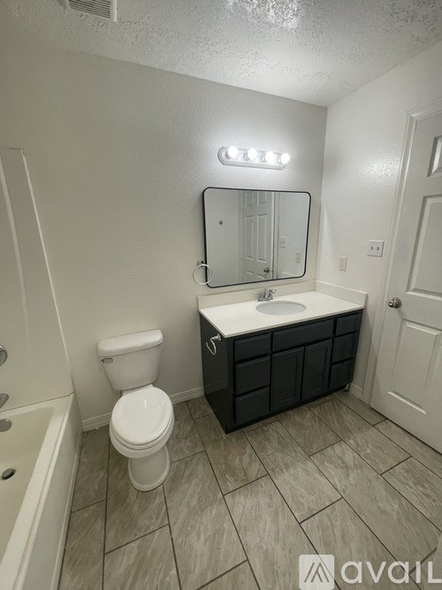 A bathroom with a toilet, sink, and mirror.