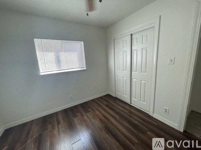 A room with a white door and a window with blinds.