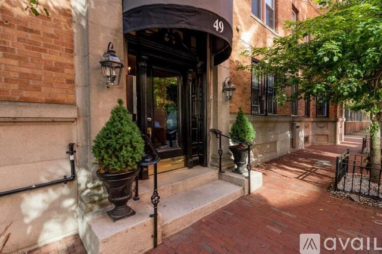 A building entrance with a black awning and a number 49 on it.
