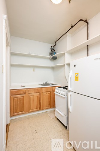A kitchen with a white fridge and wooden cabinets.