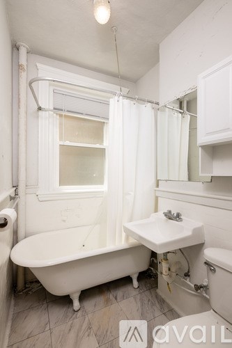 A white bathroom with a tub, sink and mirror.