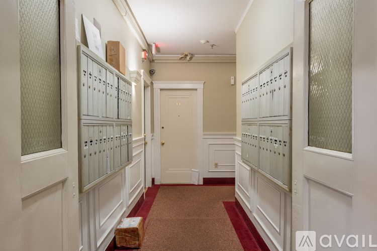 A hallway with a red carpet and white walls.