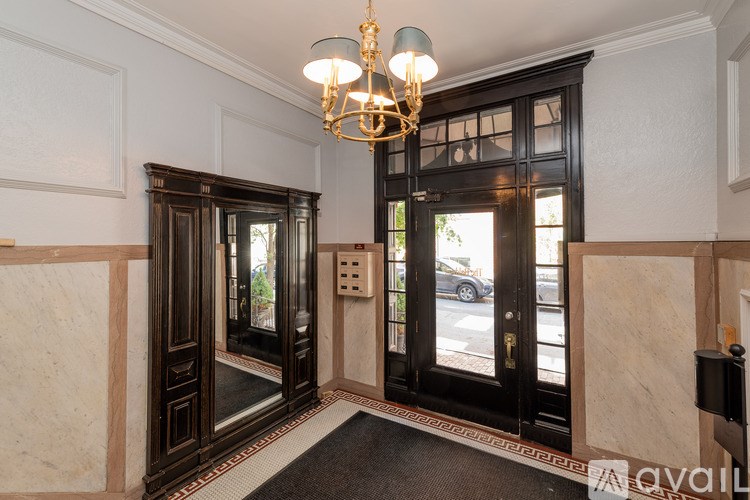 A hallway with a chandelier and two doors.