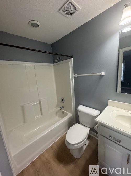 A bathroom with a toilet, sink, and bathtub.