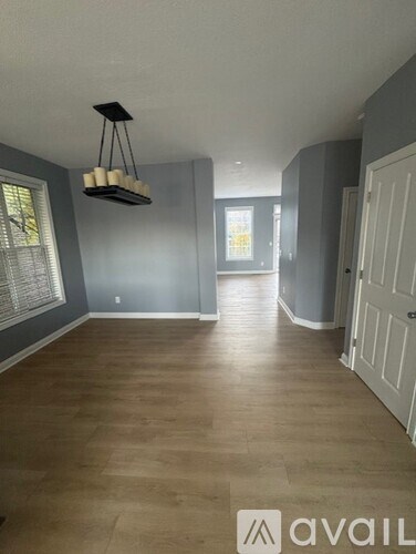 A room with wooden flooring and a hanging light fixture.