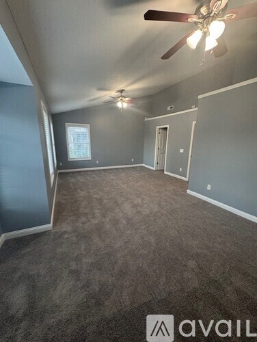 A room with a ceiling fan and carpeted floor.