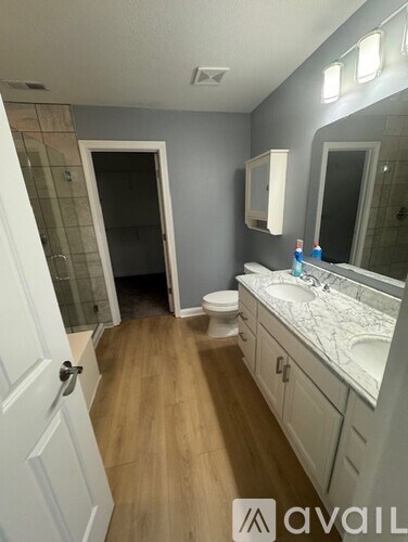 A bathroom with a toilet, sink, and mirror.