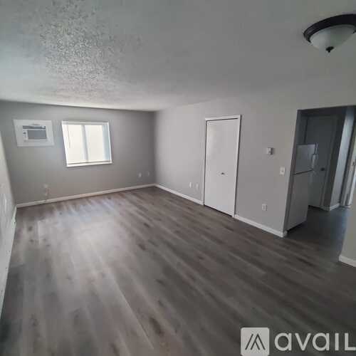 A room with wooden flooring and a window.