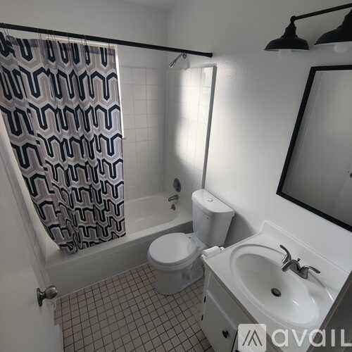 A bathroom with a toilet, sink, and shower curtain.