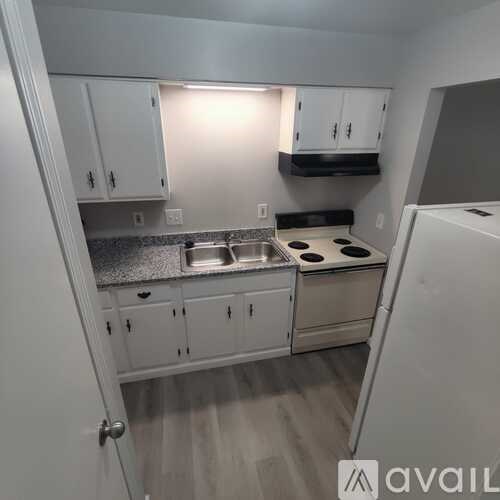 A kitchen with white cabinets and a stove top oven.