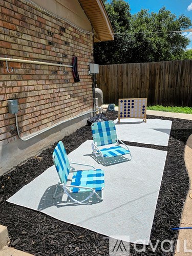 Two blue and white striped chairs are on a concrete patio.