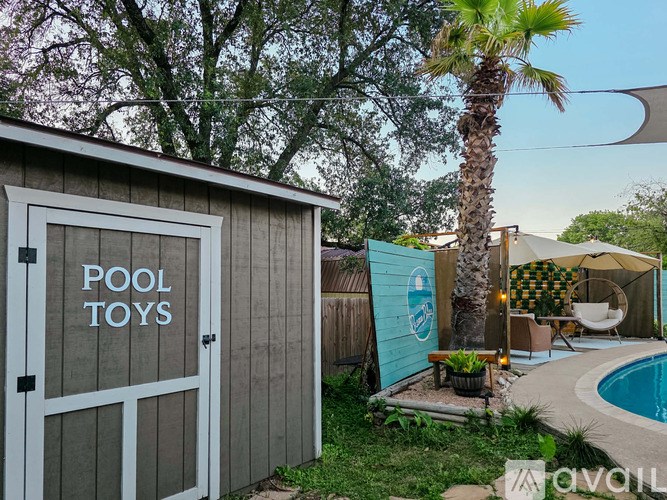 A pool toy storage shed with a door that says "POOL TOYS" on it.