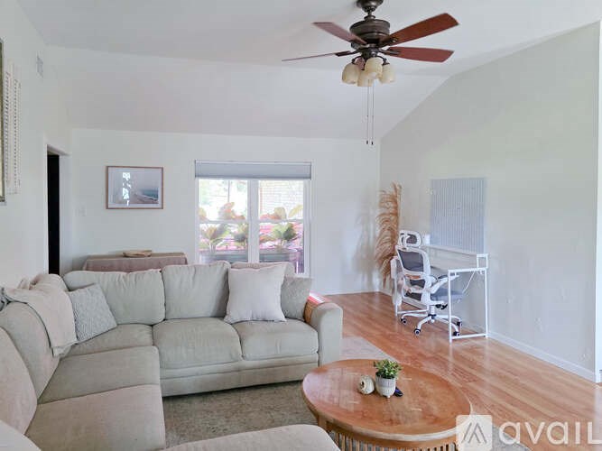 A living room with a white couch and a wooden coffee table.