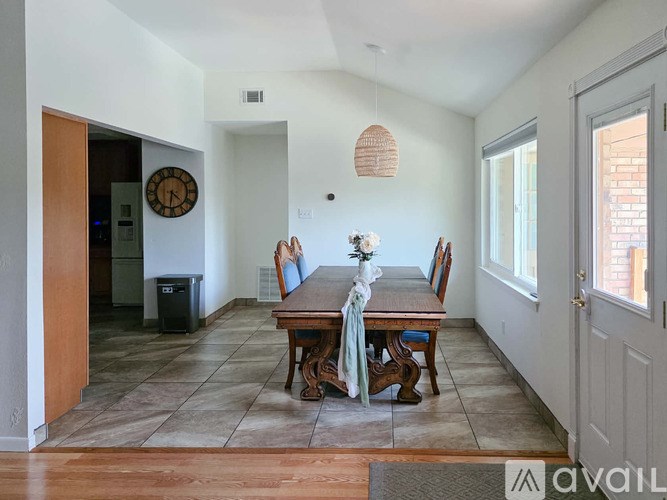 A dining room with a wooden table set for four.