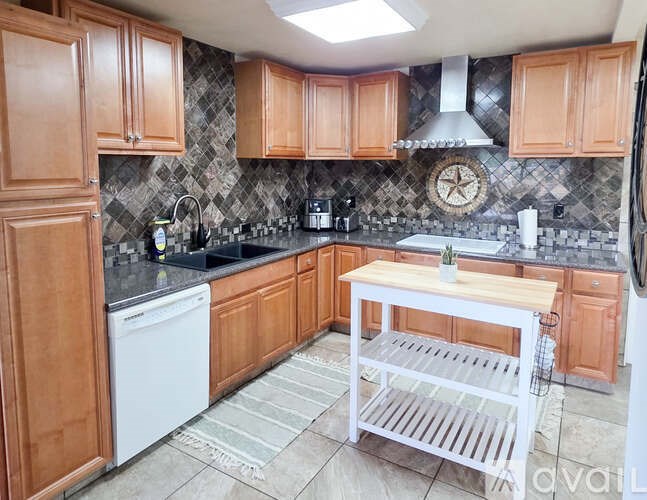 A kitchen with wooden cabinets and a white dishwasher.