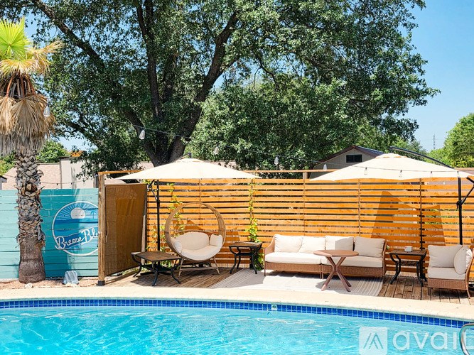 A pool area with a wooden fence and a white umbrella.