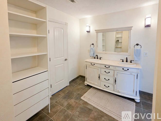 A bathroom with a white vanity and a white cabinet.