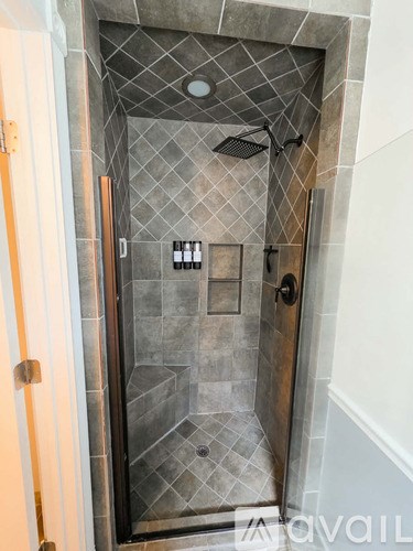 A bathroom with a walk in shower and a glass door.