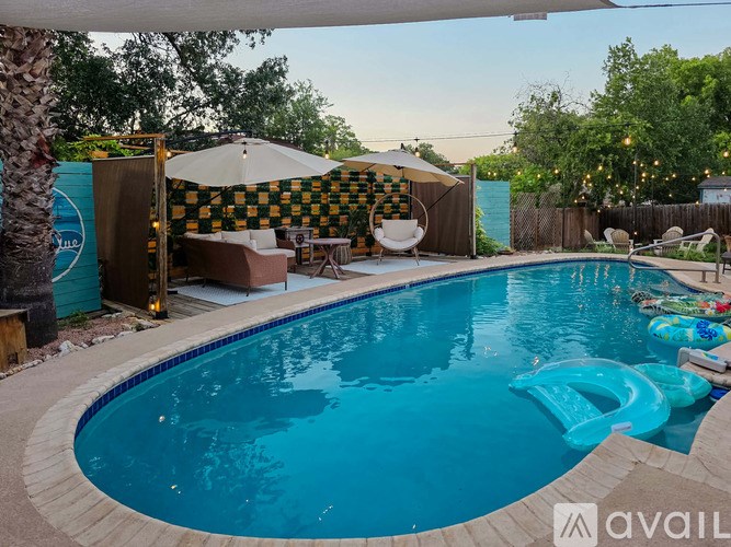A pool with a blue tinted water and a white inflatable float.