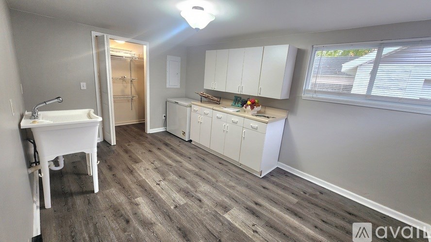 A small, clean, and organized kitchen with wood flooring and white appliances.