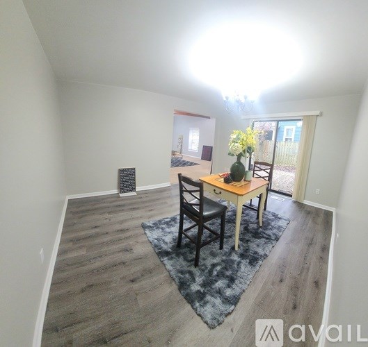 A dining room with a table and chairs.