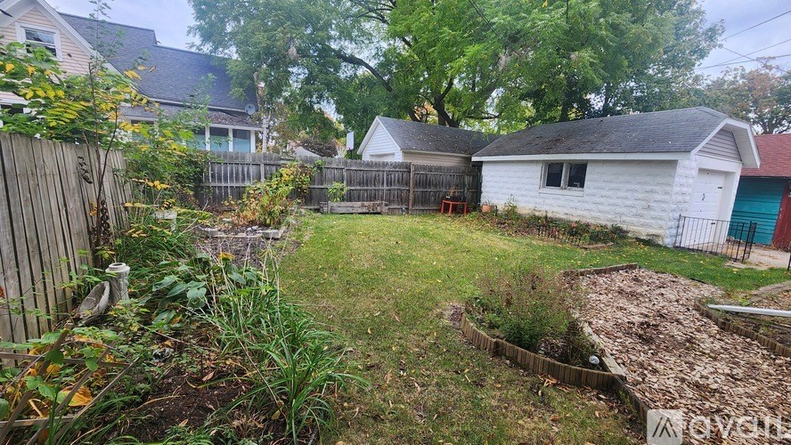 A backyard with a white shed and a wooden fence.