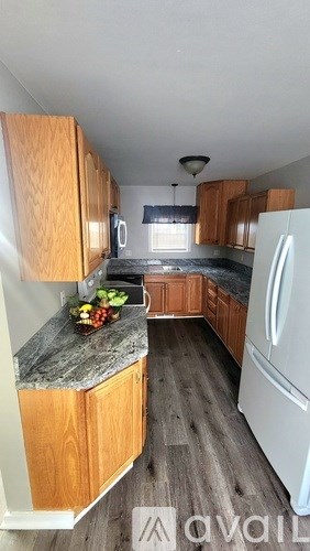 A kitchen with wooden cabinets and a marble countertop.