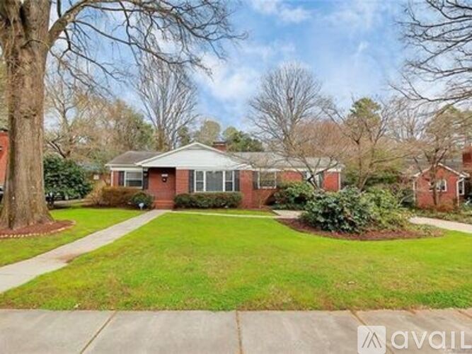 A house with a white porch and a green lawn.