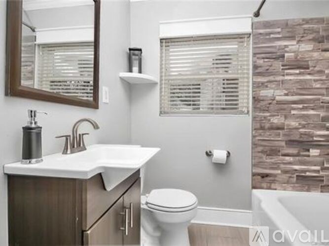 A bathroom with a toilet, sink, and a mirror.