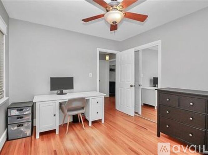 A room with a desk and a chair in it.