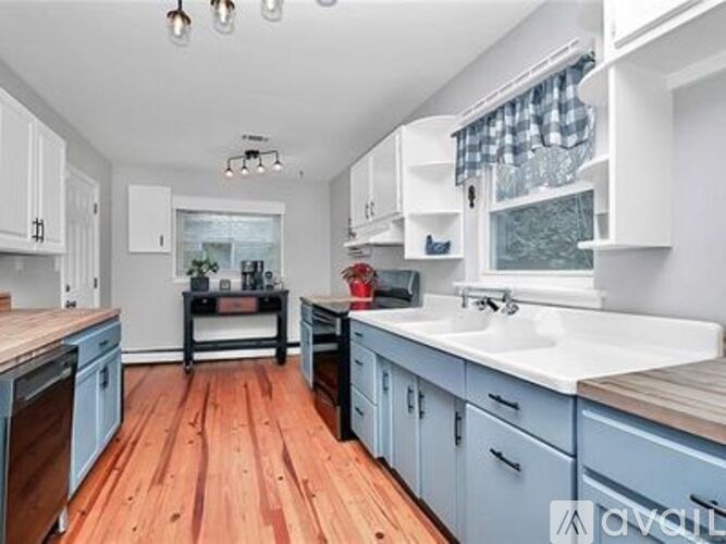 A kitchen with wooden floors and blue cabinets.