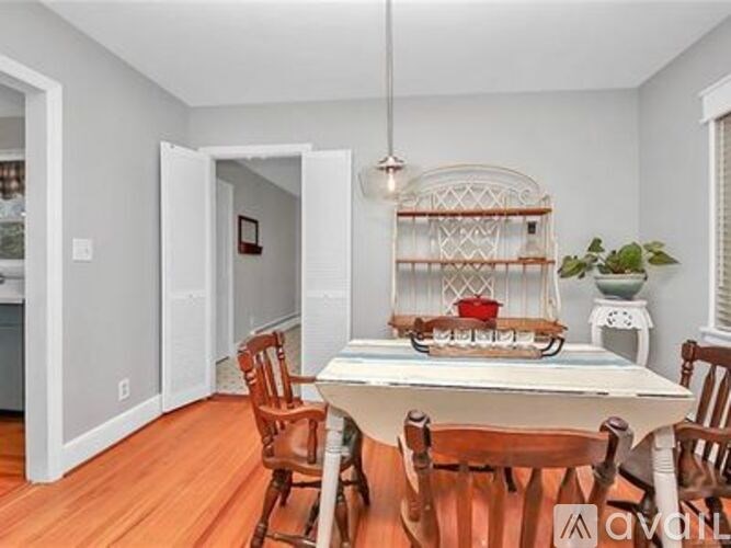 A dining room with a white table and chairs.