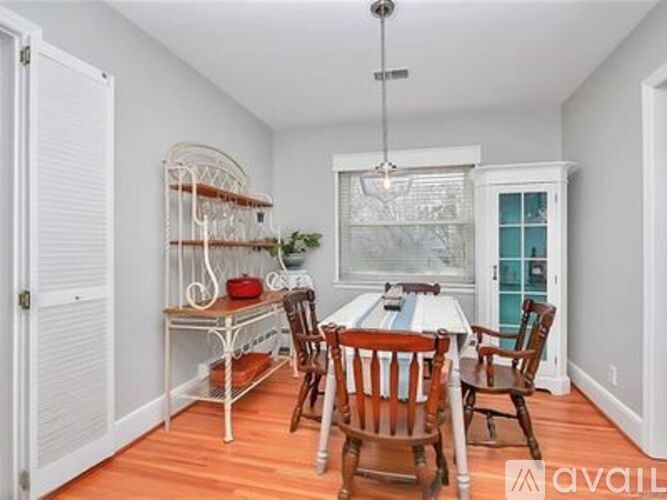 A dining room with a white table and chairs.
