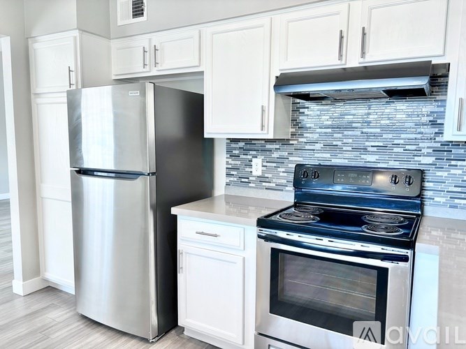 A modern kitchen with a stainless steel refrigerator, oven, and microwave.