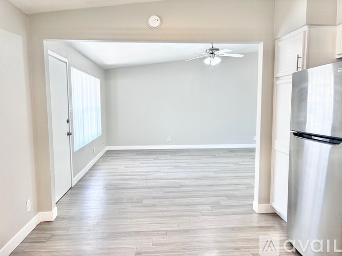 A kitchen with a refrigerator and a ceiling fan.