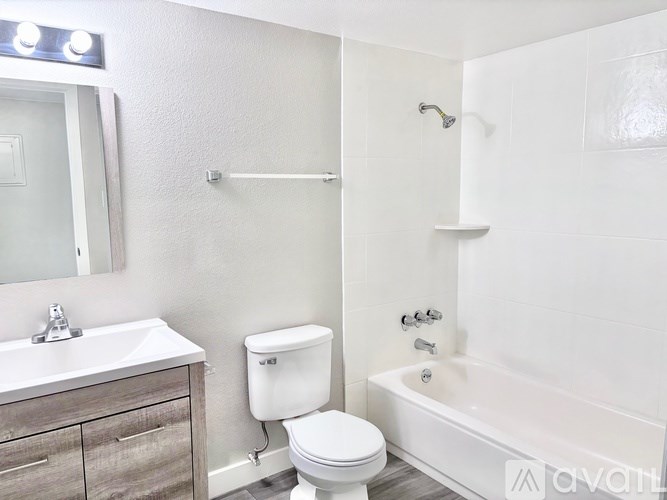 A white bathroom with a toilet, sink, and bathtub.