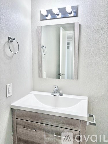 A bathroom with a white sink and a mirror above it.
