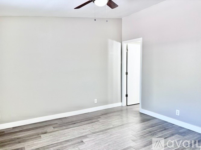 A room with a ceiling fan and a door.